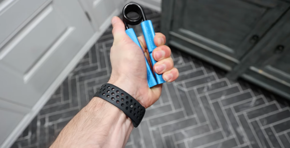 hand gripping a blue exercise tool hand gripping a blue exercise tool