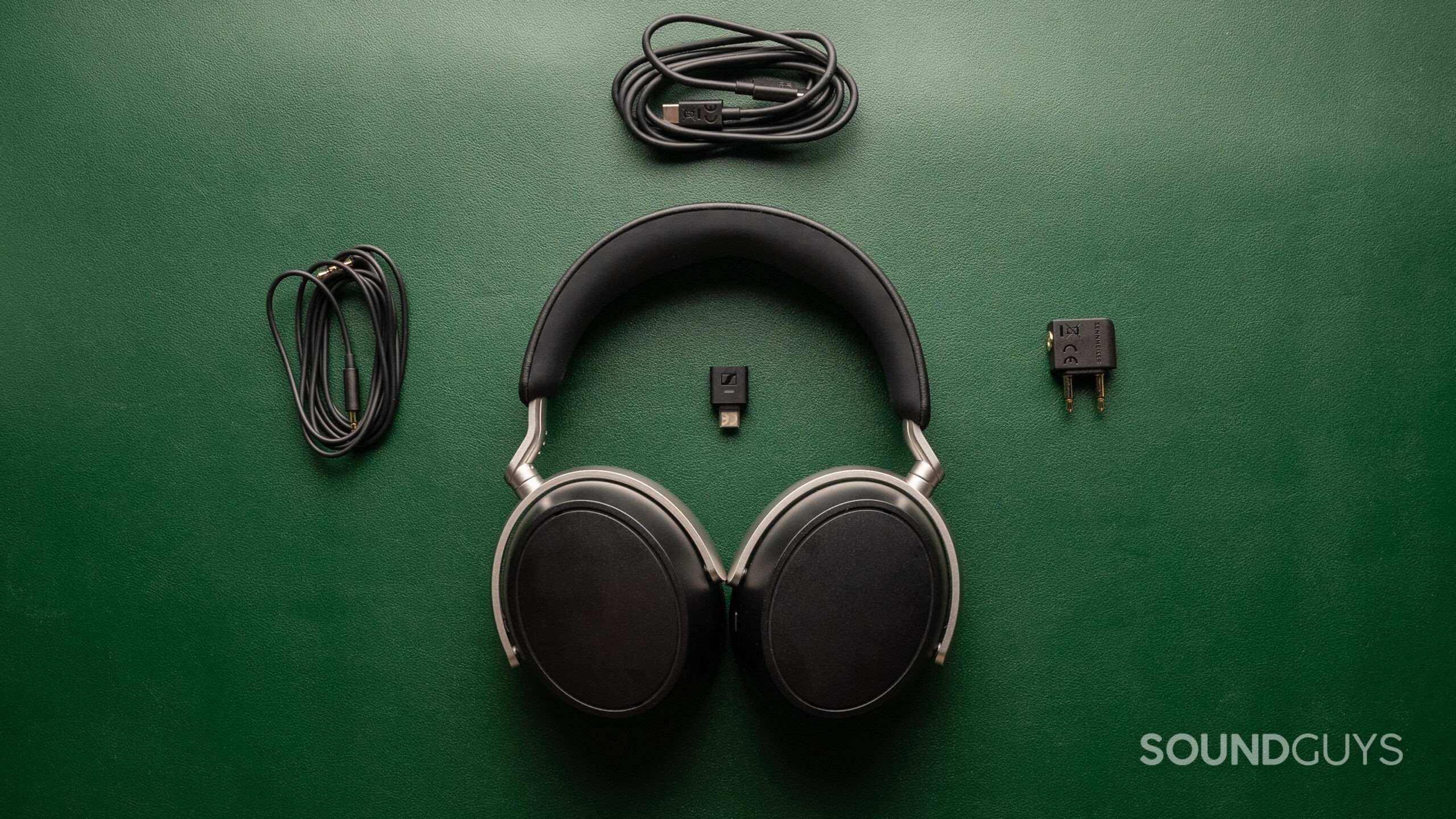 A top-down photo showing the Sennheiser HDB 630 and all of its cables and adapters.