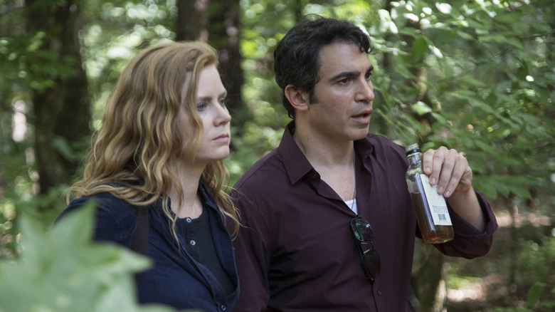 Amy Adams and Chris Messina as Camille Preaker and Detective Richard Willis, walking in the woods together in Sharp Objects