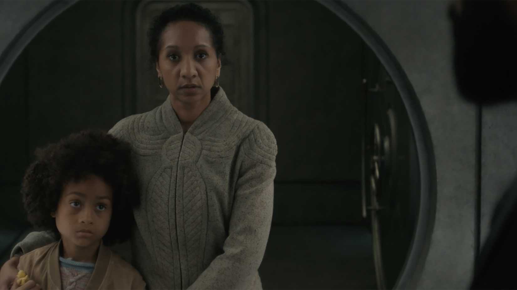 Camille hugging her son in the vault and looking scared as Sims looks at her in Silo