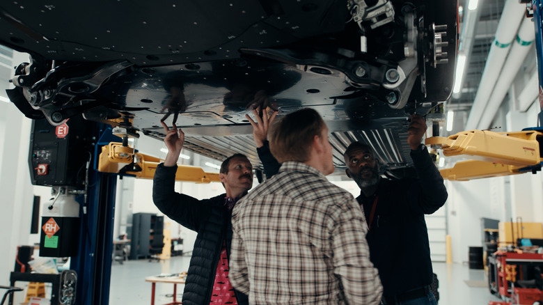 Engineers looking at the underbody of a Ford EV prototype