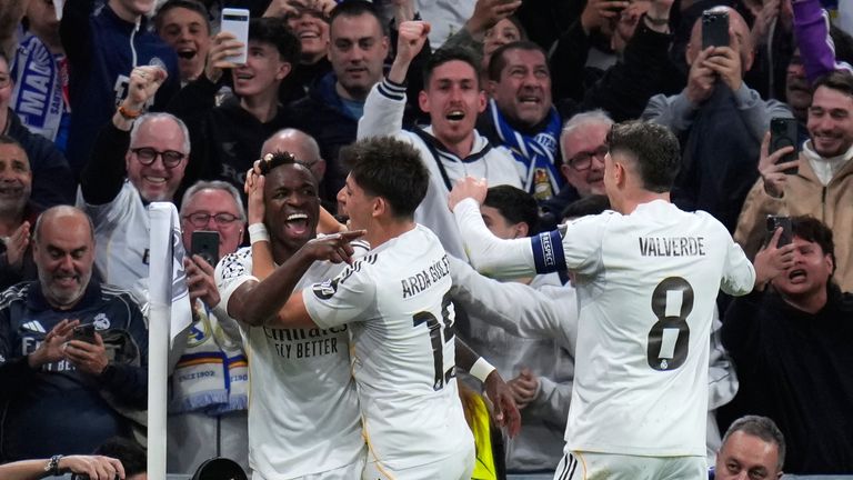 Real Madrid's Vinicius Junior, left, celebrates with teammates after scoring his side's second goal during the second leg of the Champions League playoff soccer match between Real Madrid and Benfica in Madrid, Spain, Wednesday, Feb. 25, 2026. (AP Photo/Manu Fernandez)