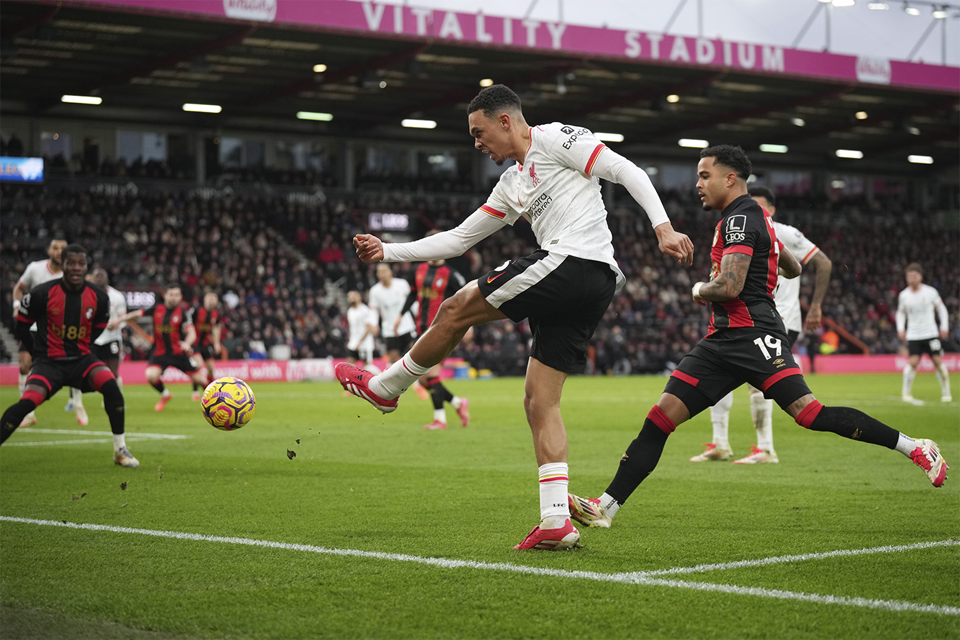 Trent Alexander-Arnold, a player for the Liverpool soccer team in Engalnd, kicking the ball on the pitch during a game.