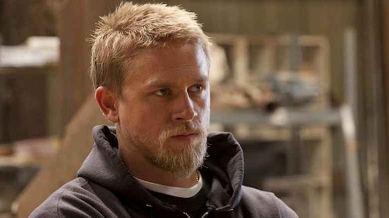 Jax Teller (Charlie Hunnam) stands sternly while wearing a hoodie in Sons of Anarchy