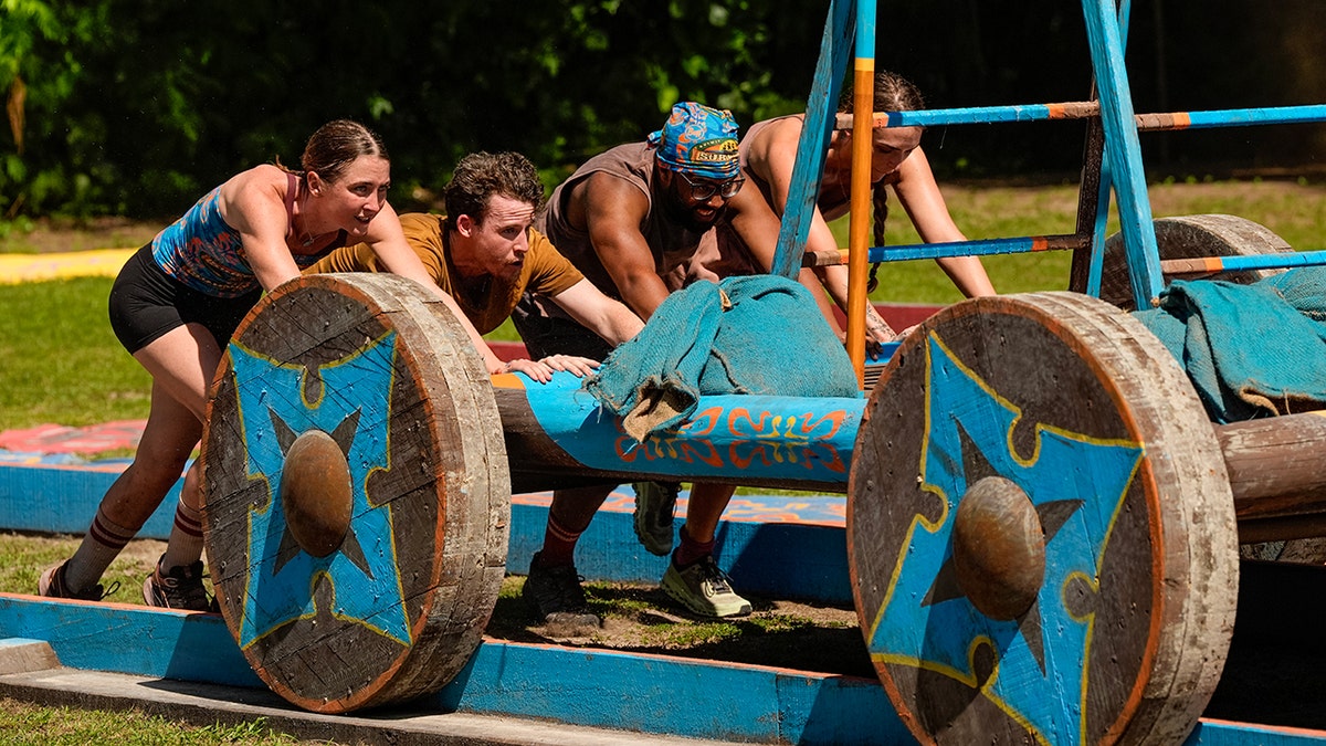 Survivor contestants pushing a wheel as part of a challenge in October 2025.