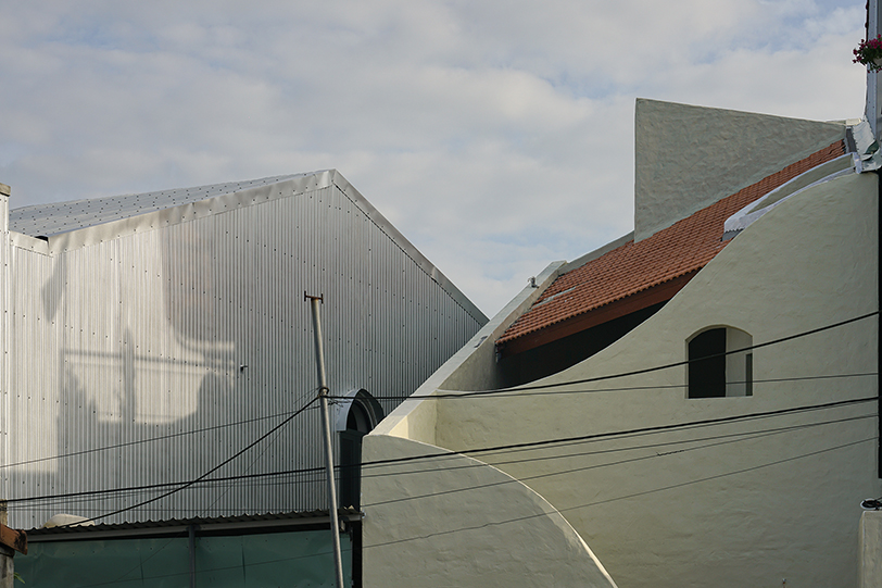 curved cutouts sculpt fluid voids within gabled residence in vietnam