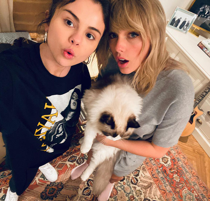Selena Gomez and Taylor Swift posing indoors with a cat, capturing a moment amid gift backlash rumors. Selena Gomez and Taylor Swift posing indoors with a cat, capturing a moment amid gift backlash rumors.