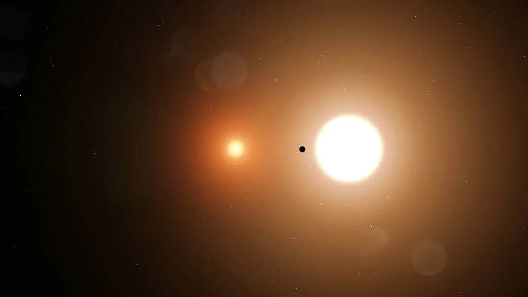An artist's depiction of a planet, represented by the black circle, orbiting a pair of stars — a so-called binary star system. Credit: NASA/Goddard Space Flight Center