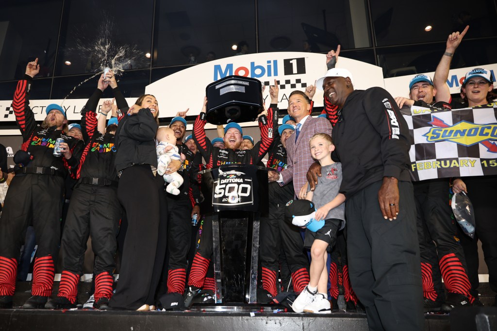Tyler Reddick, driver of the #45 Chumba Casino Toyota, lifts the Harley J. Earl Trophy in victory lane after winning the NASCAR Cup Series Daytona 500 at Daytona International Speedway on February 15, 2026 in Daytona Beach, Florida.  