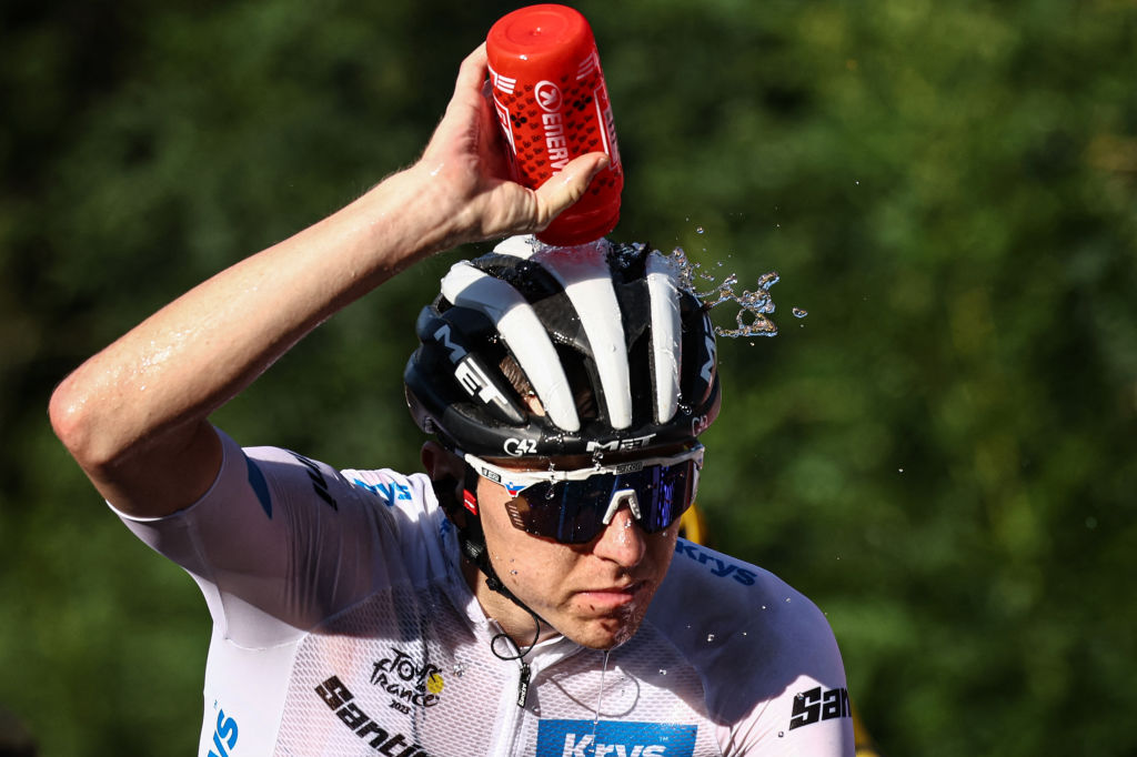 UAE Team Emirates' Slovenian rider Tadej Pogacar wearing the best young rider's white jersey douses himself with water to cool down as he cycles in the final ascent of Saint-Gervais-les-Bains in the last kilometers of the 15th stage of the 110th edition of the Tour de France cycling race, 179 km between Les Gets Les Portes du Soleil and Saint-Gervais Mont-Blanc, in the French Alps, on July 16, 2023. (Photo by Anne-Christine POUJOULAT / AFP)
