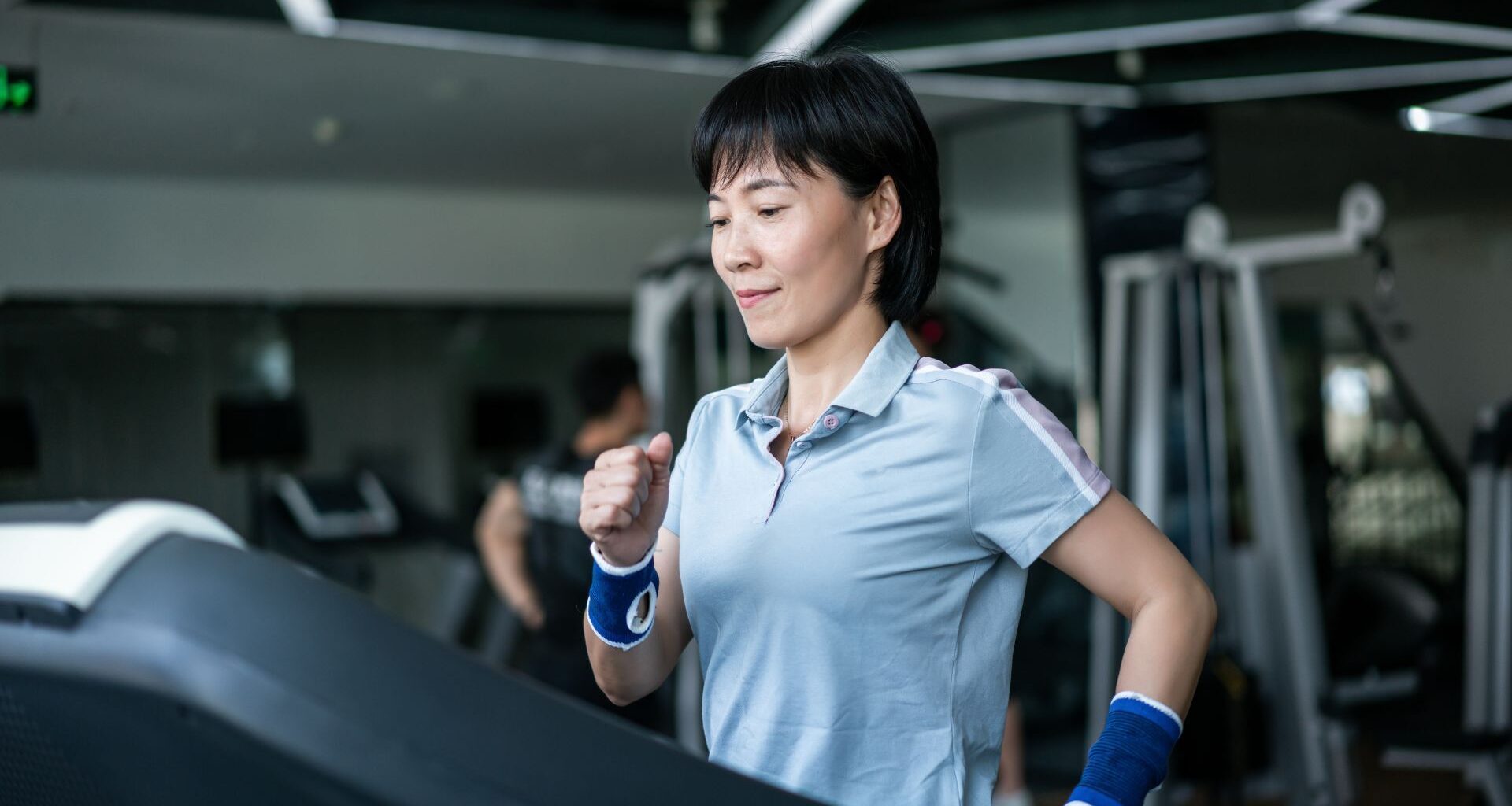 Woman doing incline walking workout at a gym