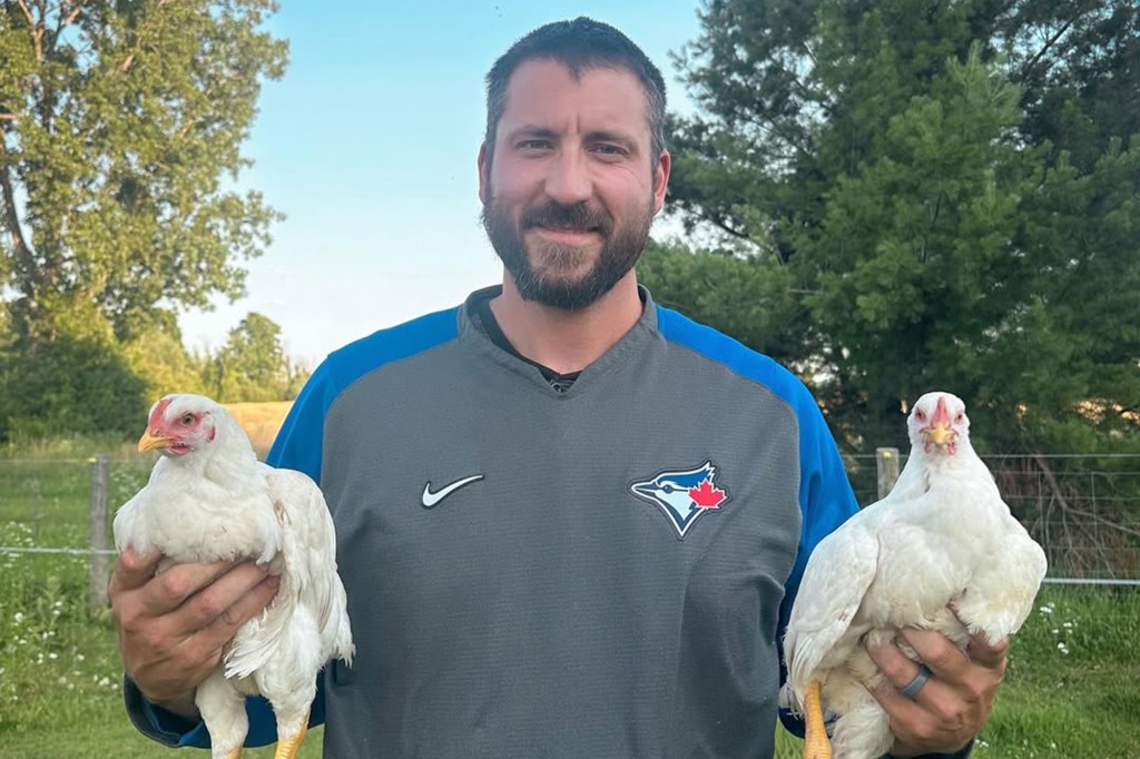 Phillipe Aumont holding two chickens.