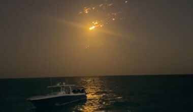 debris from spacex starship falling over a boat in the ocean