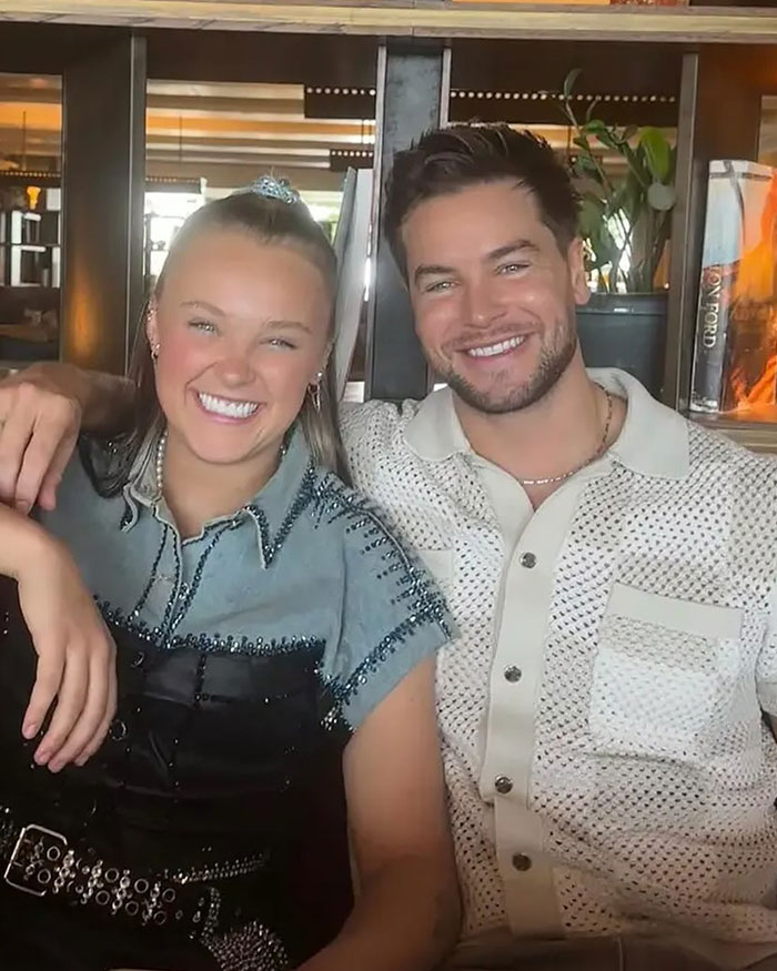 JoJo Siwa and Chris Hughes smiling together, sharing a moment amid wedding aftermath and personal reflections.