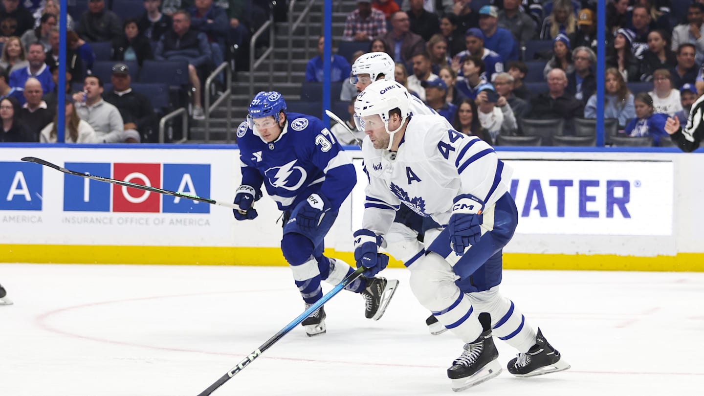 Feb 25, 2026; Tampa, Florida, USA; Toronto Maple Leafs defenseman Morgan Rielly (44) skates with the puck with Tampa Bay Lightning forward Yanni Gourde (37) behind him during the third period at Benchmark International Arena. Mandatory Credit: Morgan Tencza-Imagn Images