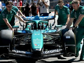 Mechanics take the car of Aston Martin's Canadian driver Lance Stroll for scrutineering ahead of the Formula 1 Australian Grand Prix.