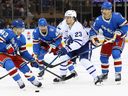 Matthew Knies of the Toronto Maple Leafs is surrounded by New York Rangers players during a game last week.