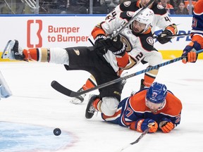 Anaheim Ducks' Benoit-Olivier Groulx (24) and Edmonton Oilers' Brett Kulak (27) battle in front for the puck during a game in 2024.