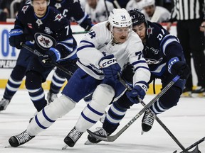 Former Toronto Maple Leafs winger Bobby McMann battles for the puck against the Winnipeg Jets earlier this year.