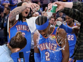 Oklahoma City Thunder forward Jaylin Williams, left, and other Thunder players pour water on Thunder guard Shai Gilgeous-Alexander (2) after an NBA basketball game against the Boston Celtics on March 12, 2026, in Oklahoma City.