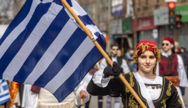 A parade participant waves the Greek flag.