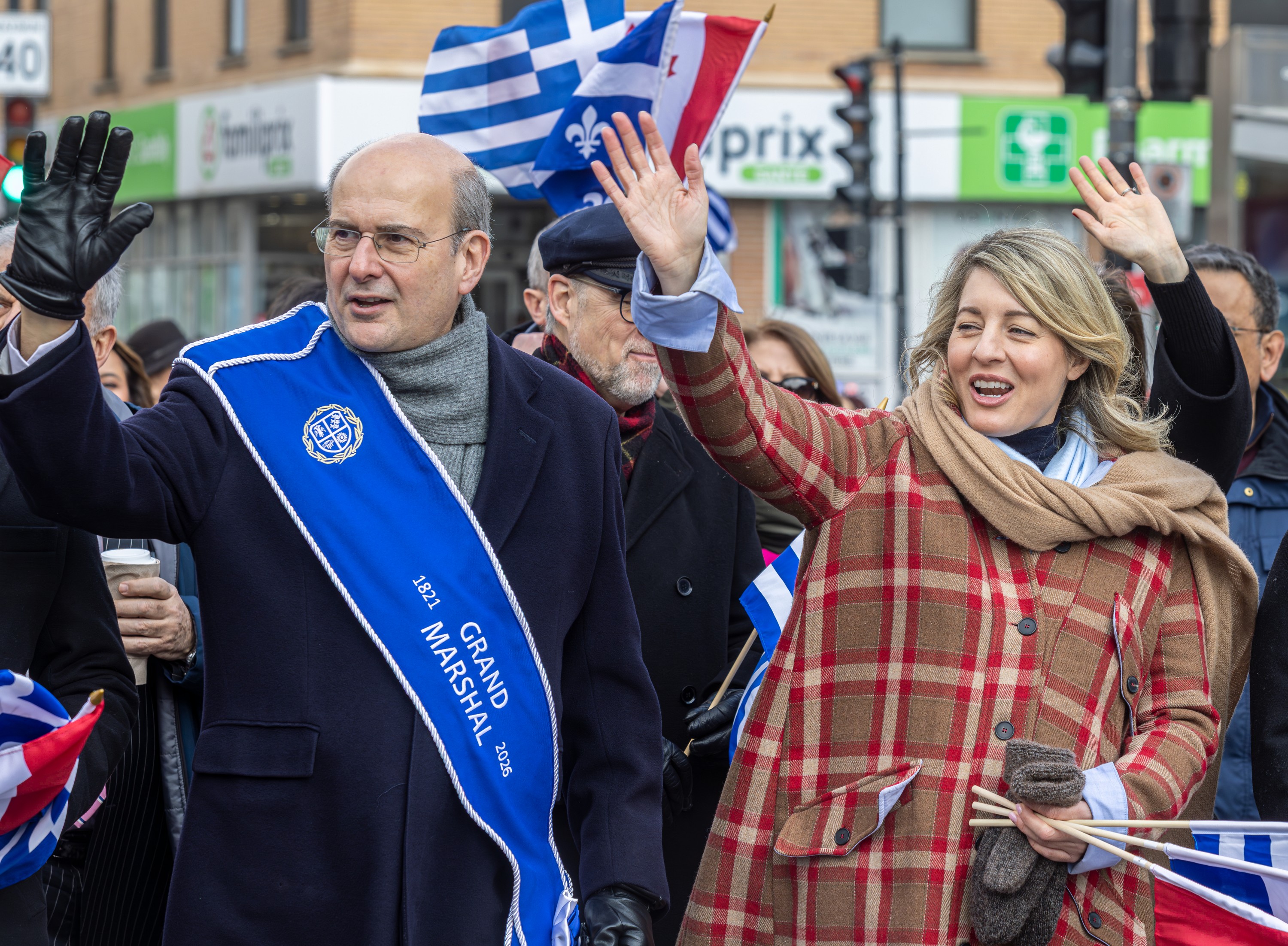 Federal industry minister Mélanie Joly waves next to Kostis Hatzidakis, deputy prime minister of Greece and parade grand marshal, in the Greek Independence Day parade in Montreal.