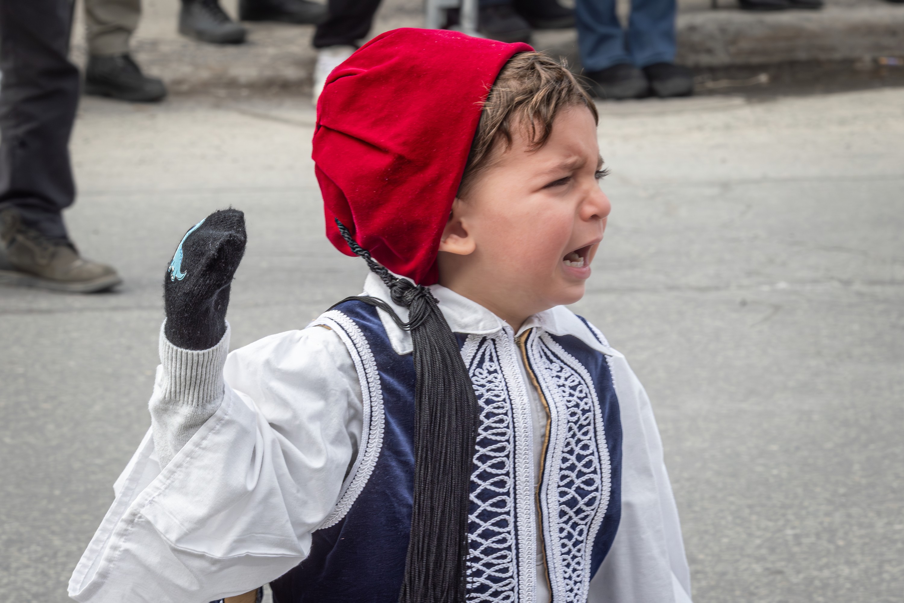 A child looks unhappy in a Greek Independence Day parade.