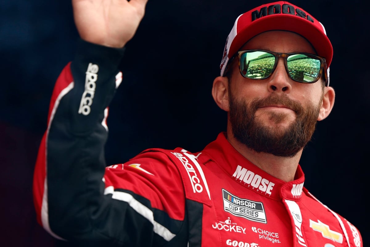 An image of Trackhouse Racing driver Ross Chastain waving to the crowd at a race
