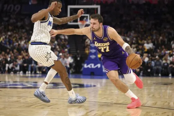 Los Angeles Lakers guard Luka Doncic (77) moves the ball past Orlando Magic forward Jamal Cain (8) in the second quarter at Kia Center.