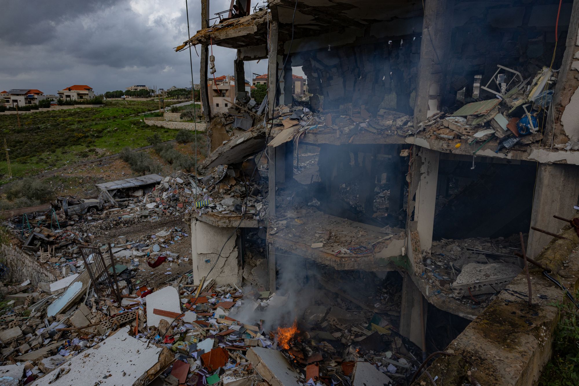 Fires still burn around the destroyed building in southern Lebanon