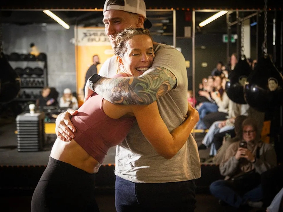 Morgan McKay exchanges a hug with gym owner Phil Green after she completed the challenge on Saturday afternoon.