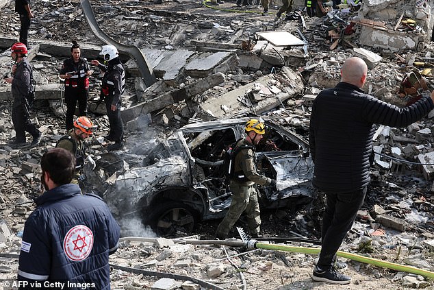 Officials search through the rubble after a missile strike in Bet Shemesh, close to Jerusalem