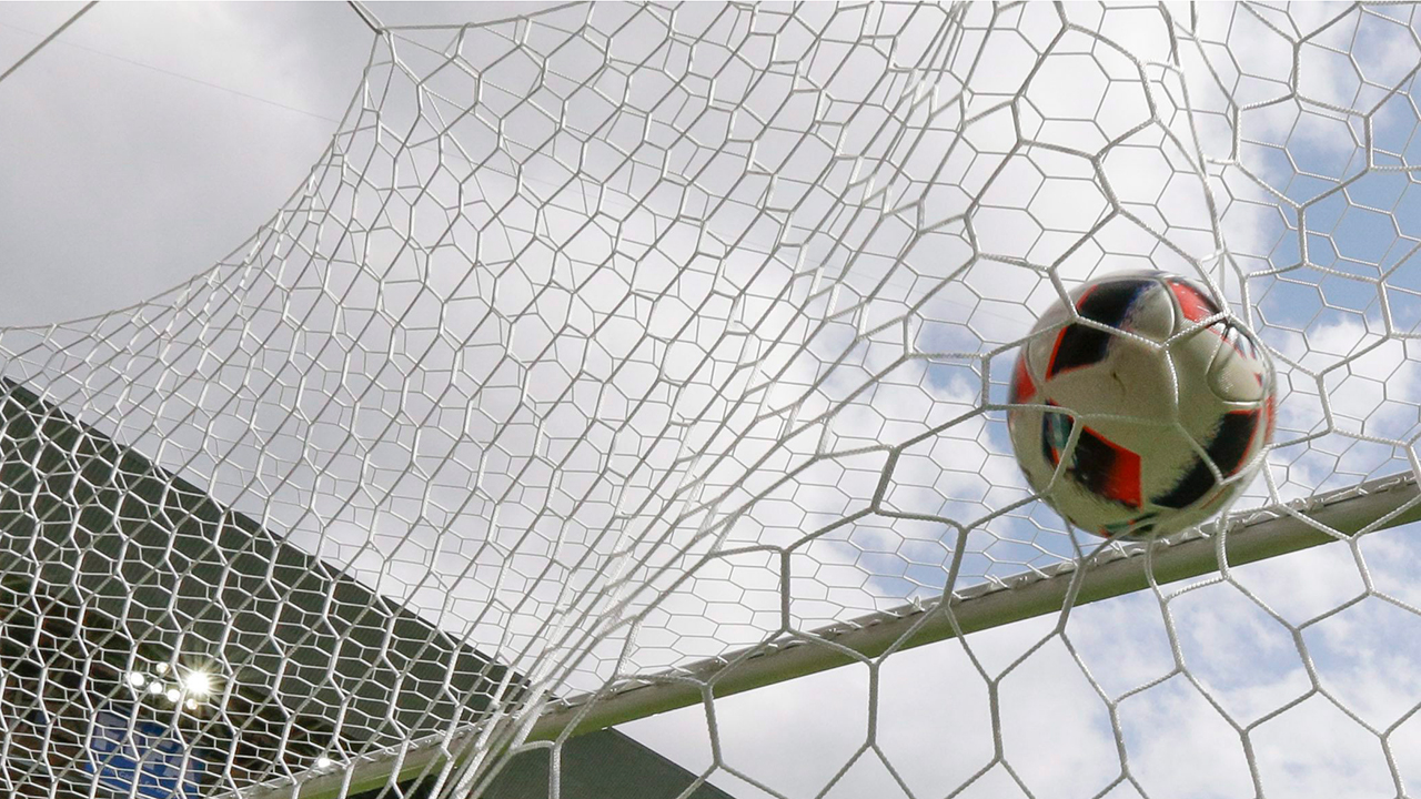 A soccer ball hits a net. (AP/Thanassis Stavrakis)