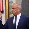 Robert F. Kennedy Jr. raises his hand at his swearing-in.