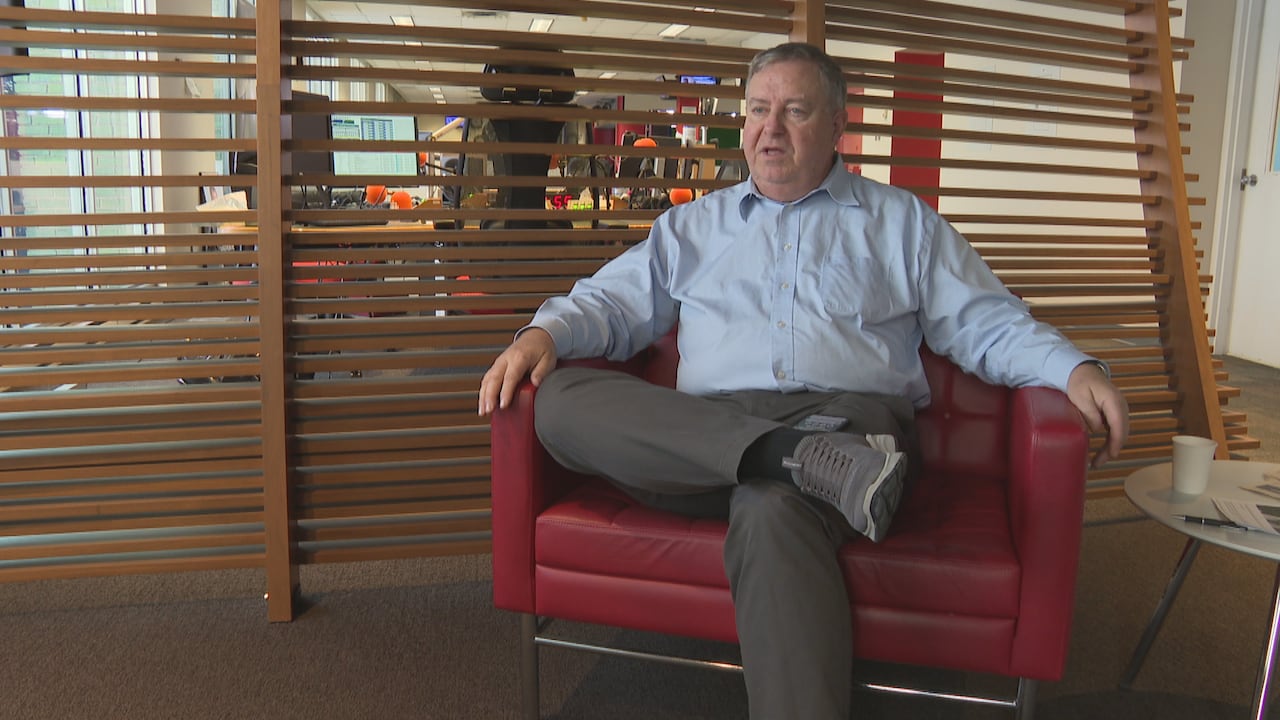 A man sits in a red chair