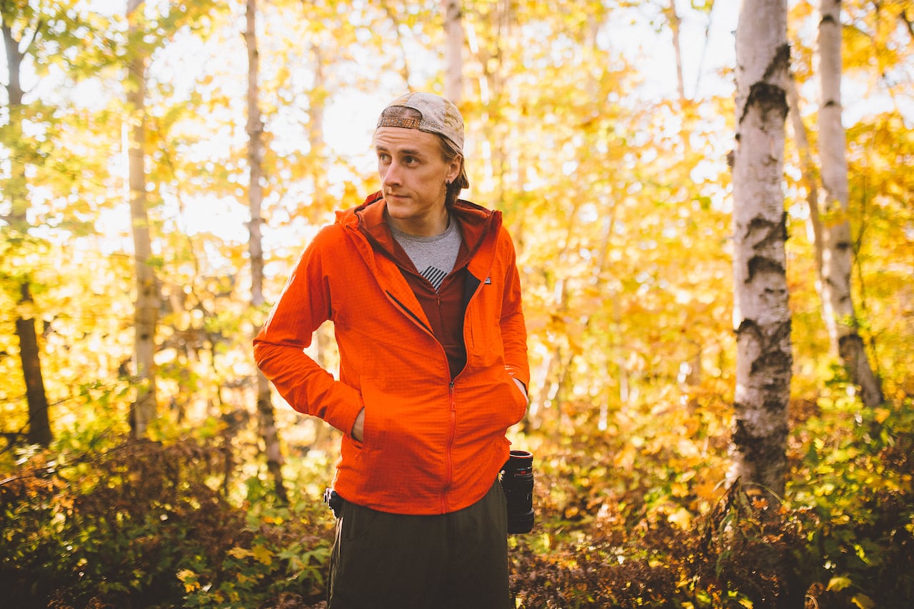 A man stands in a forested area.