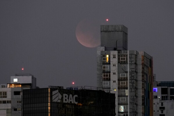 A total lunar eclipse is seen from Panama City before sunrise, Tuesday, March 3, 2026. (AP Photo/Matias Delacroix)