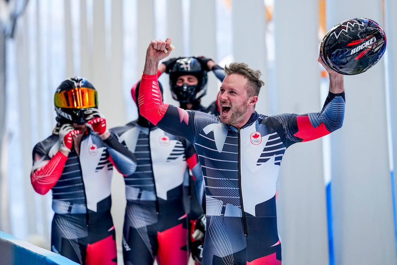 Justin Kripps, Ryan Sommer, Cam Stones and Benjamin Coakwell celebrate at the 2022 Winter Olympics, Feb. 20, 2022 