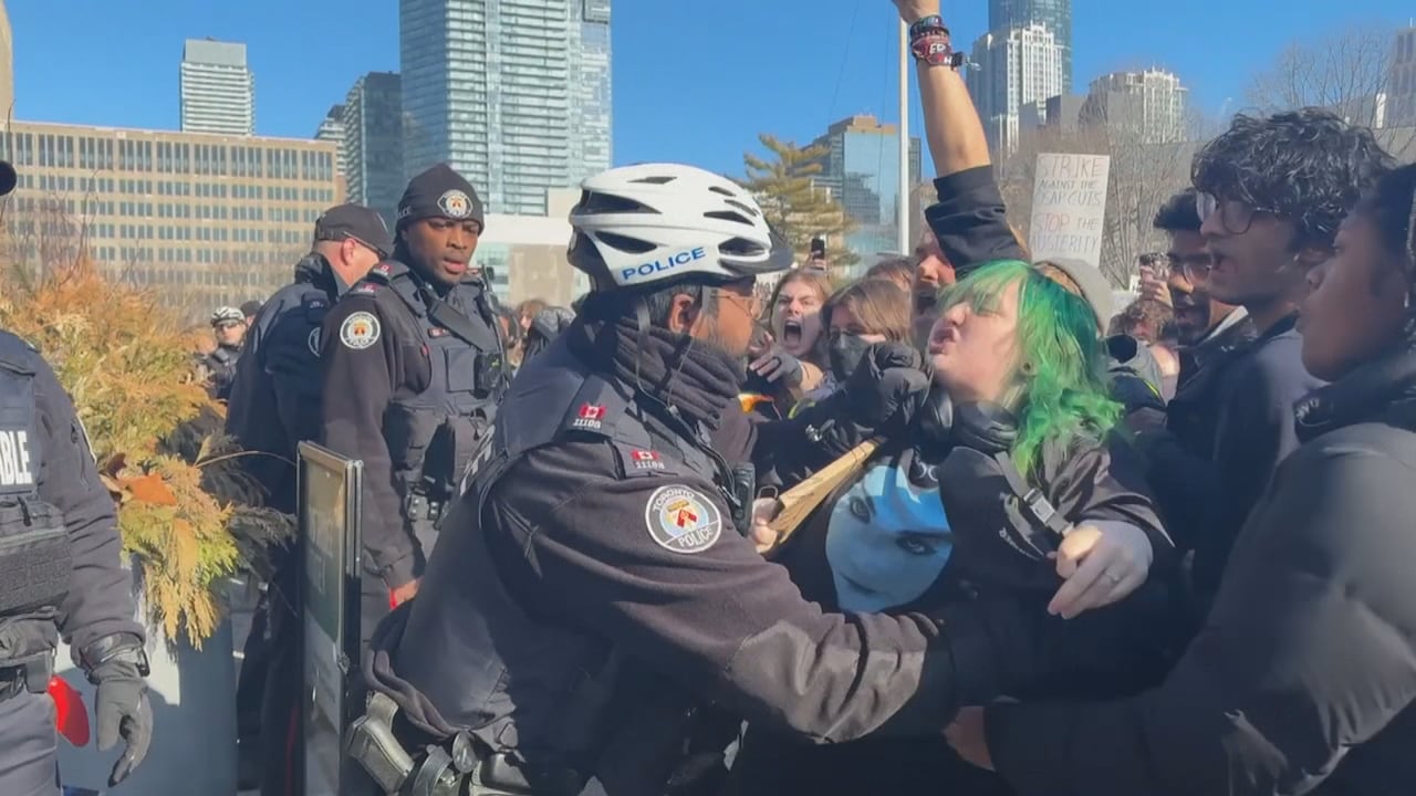 Officer pushes protester at rally.