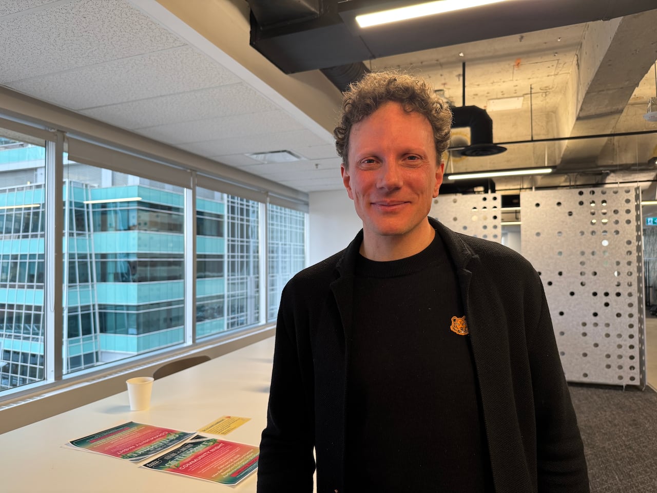 A man smiles in an office 