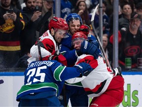 Vancouver Canucks' Elias Pettersson (25), Teddy Blueger (53), Carolina Hurricanes' Sean Walker (26) and Andrei Svechnikov (37) fight during the second period at Rogers Arena on Wednesday night