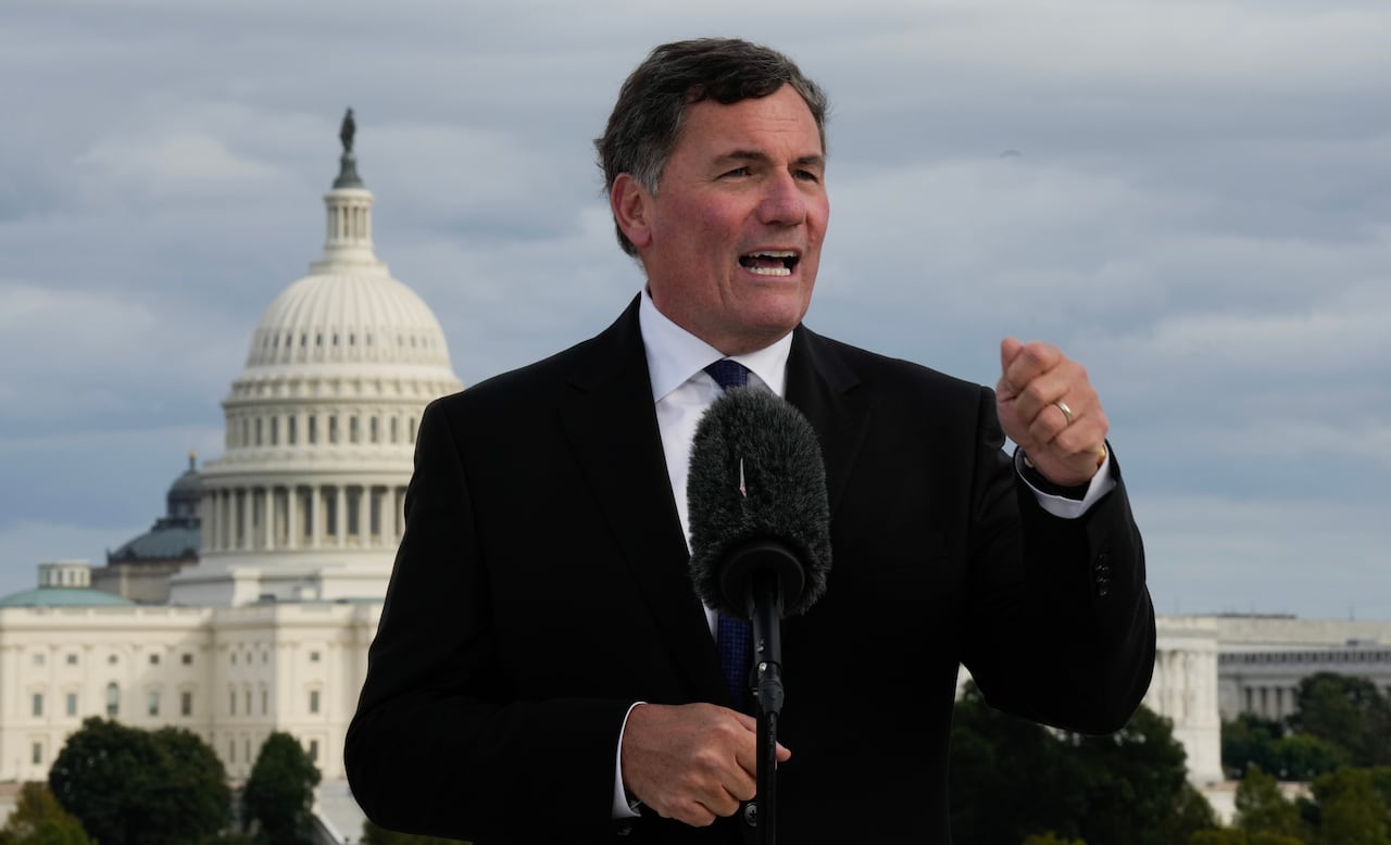 Dominic LeBlanc stands at a microphone outside with the U.S. Capitol in the background. 