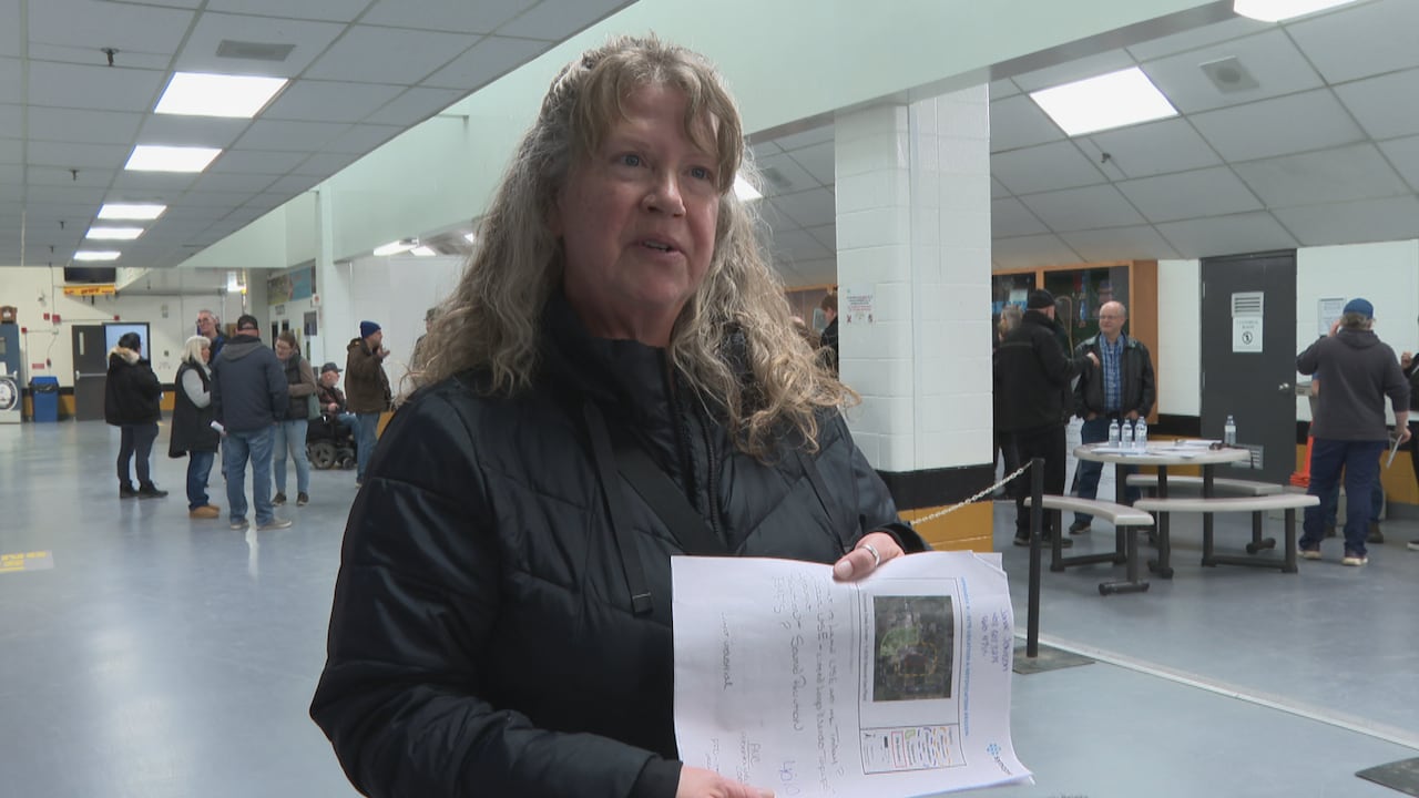 Olds, Alta. resident Rachel Sorenson holds up the project information package provided to residents at a February open house. She says she's 'elated' at the AUC's recent decision.