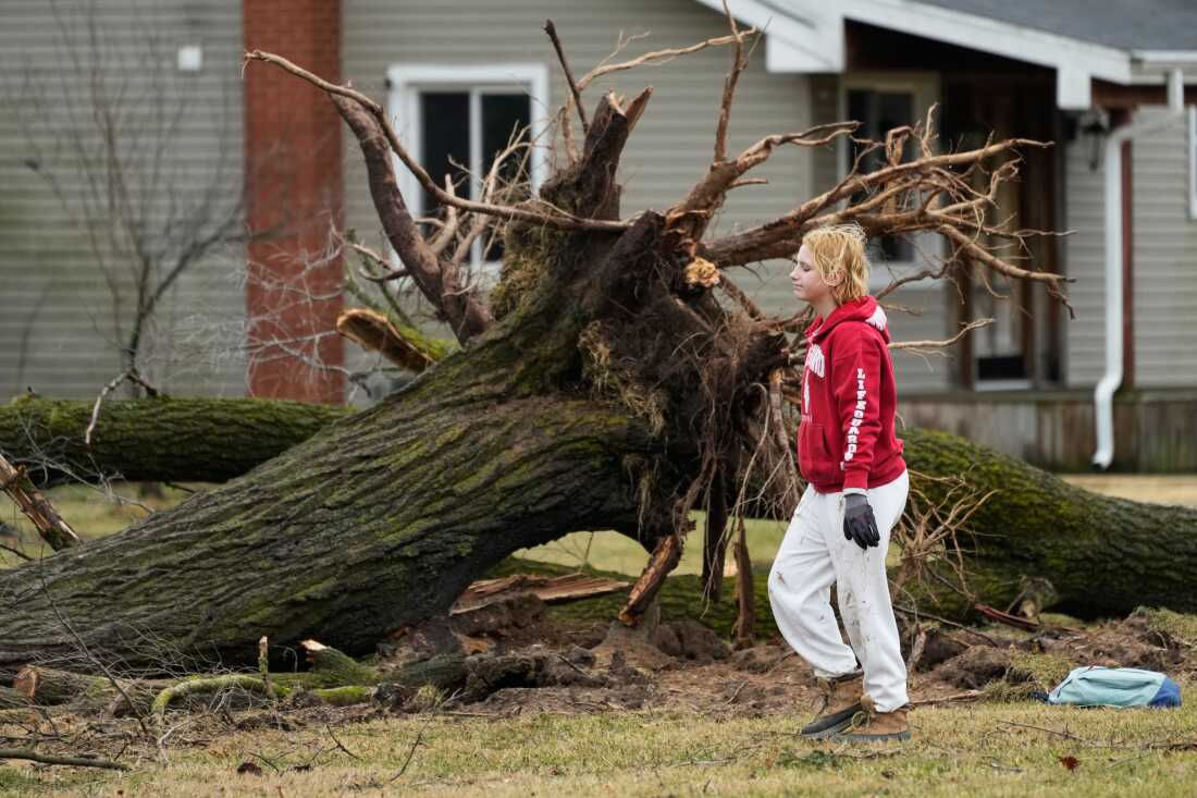 A volunteer works to clear debris a day after a storm whipped up a tornado through the area, in Union City Mich. on Saturday.