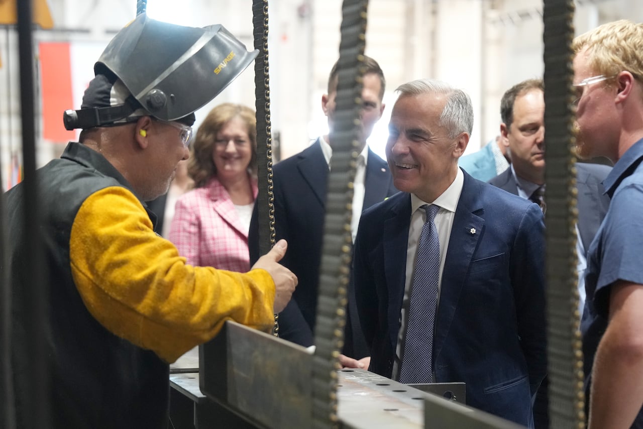 A man in a suit meets a steel worker