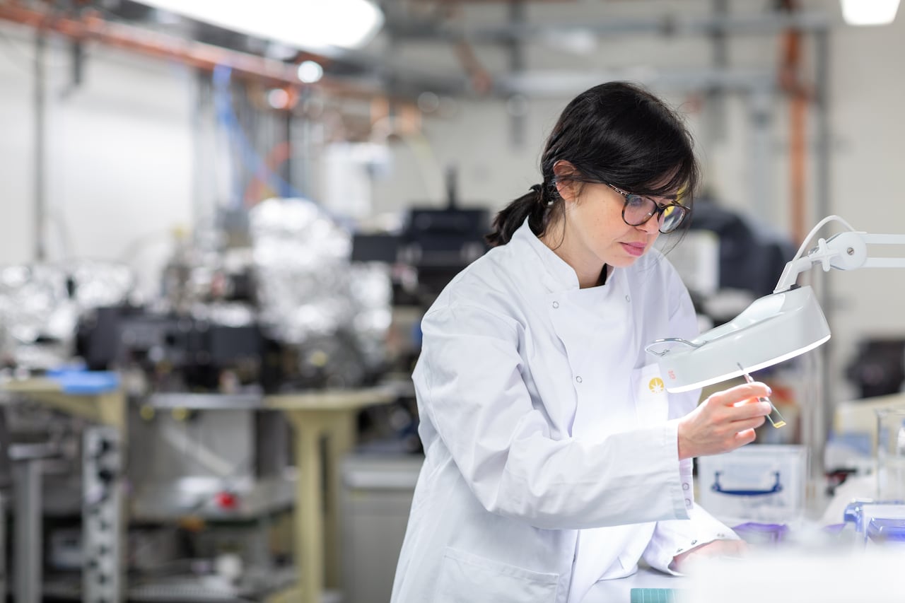 A woman with glasses is smiling.