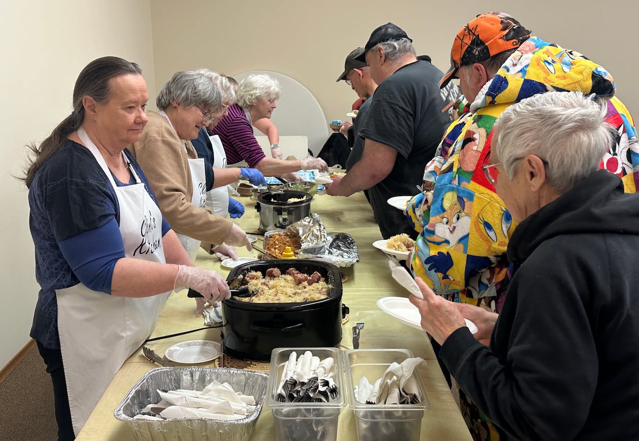 Volunteers serve meals.