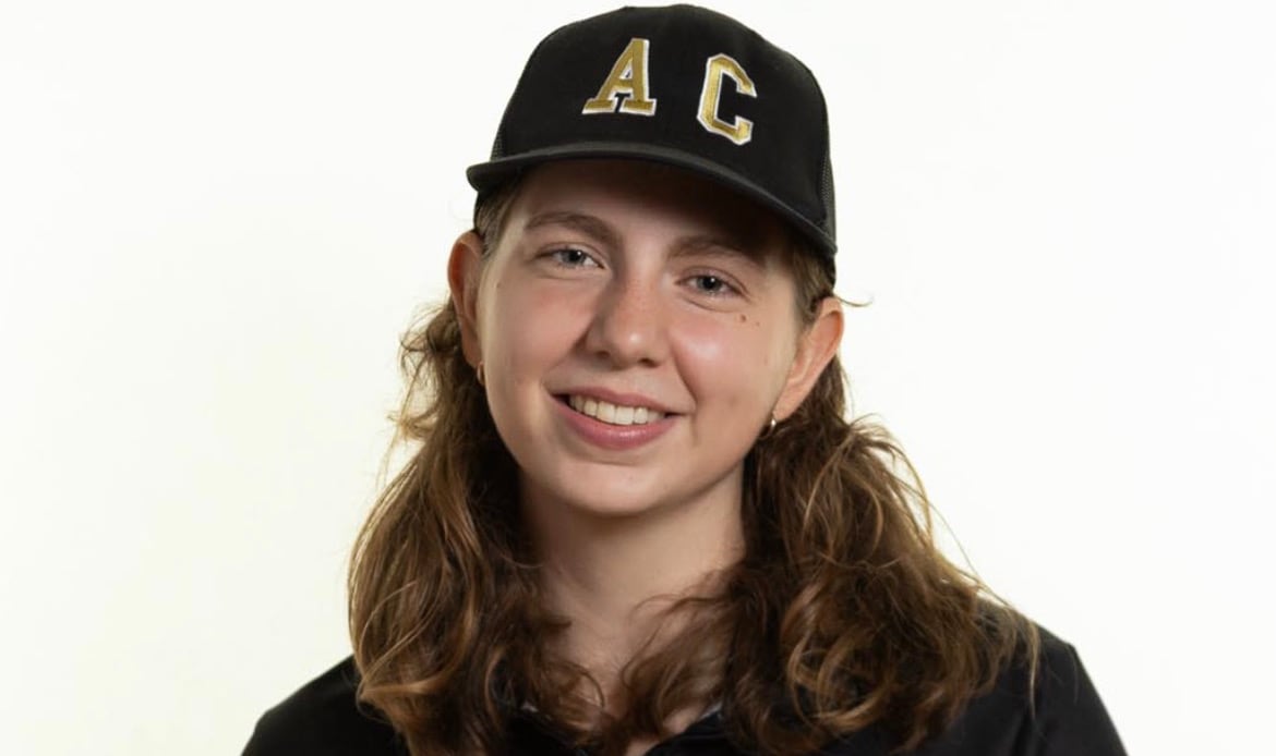 A woman wears a ball cap that says AC (agricultural campus) and a sweater that says Dal AC.