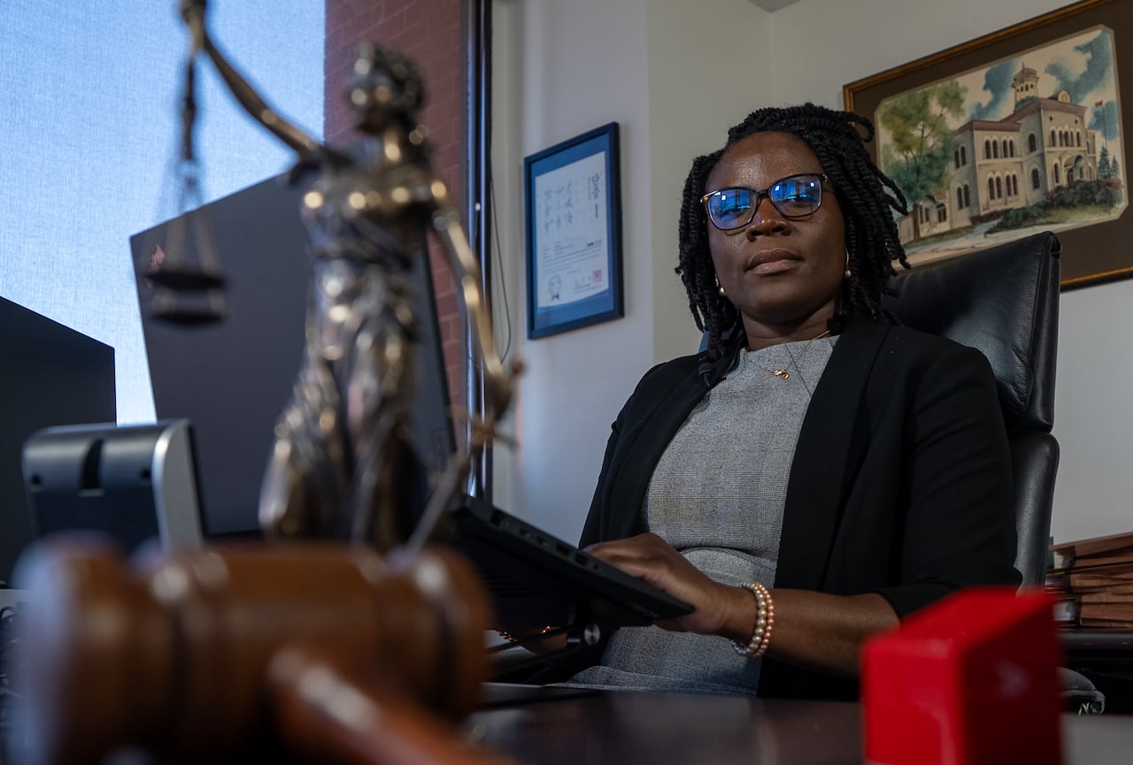 Woman sitting at desk, looking at camera