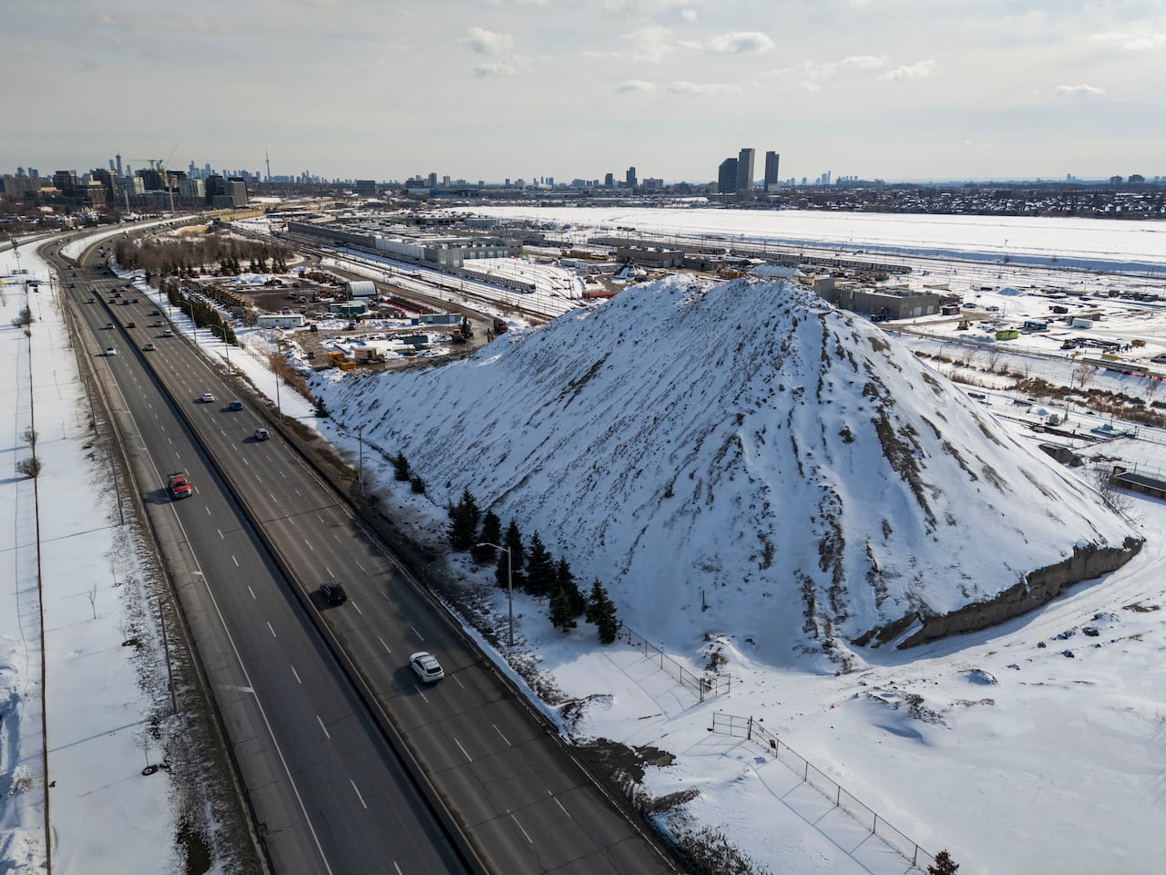 A mountain of snow cleared from Toronto streets is piled at a works yard, near Downsview Park, on Feb. 26, 2026.